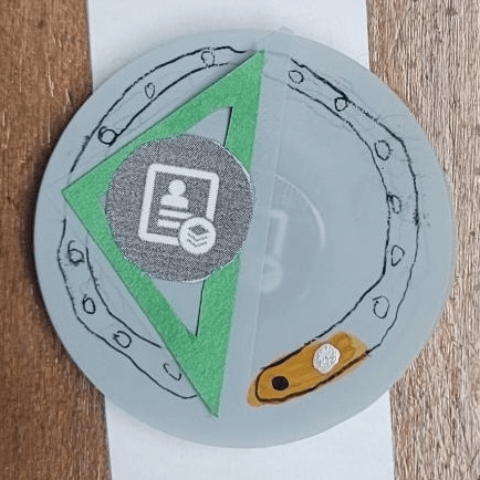 A paper prototype watch face showing the a phone contact with a solid triangle behind it.